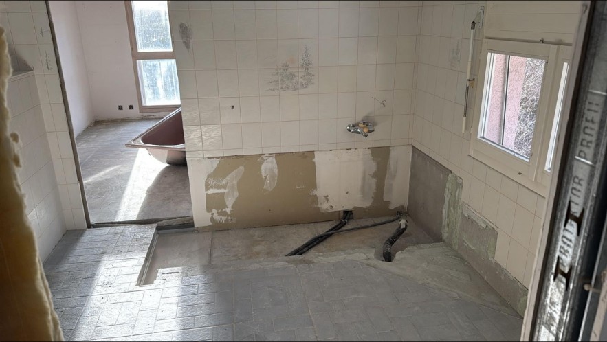 Salle de bain déposée avec réseaux apparents avant création de la douche