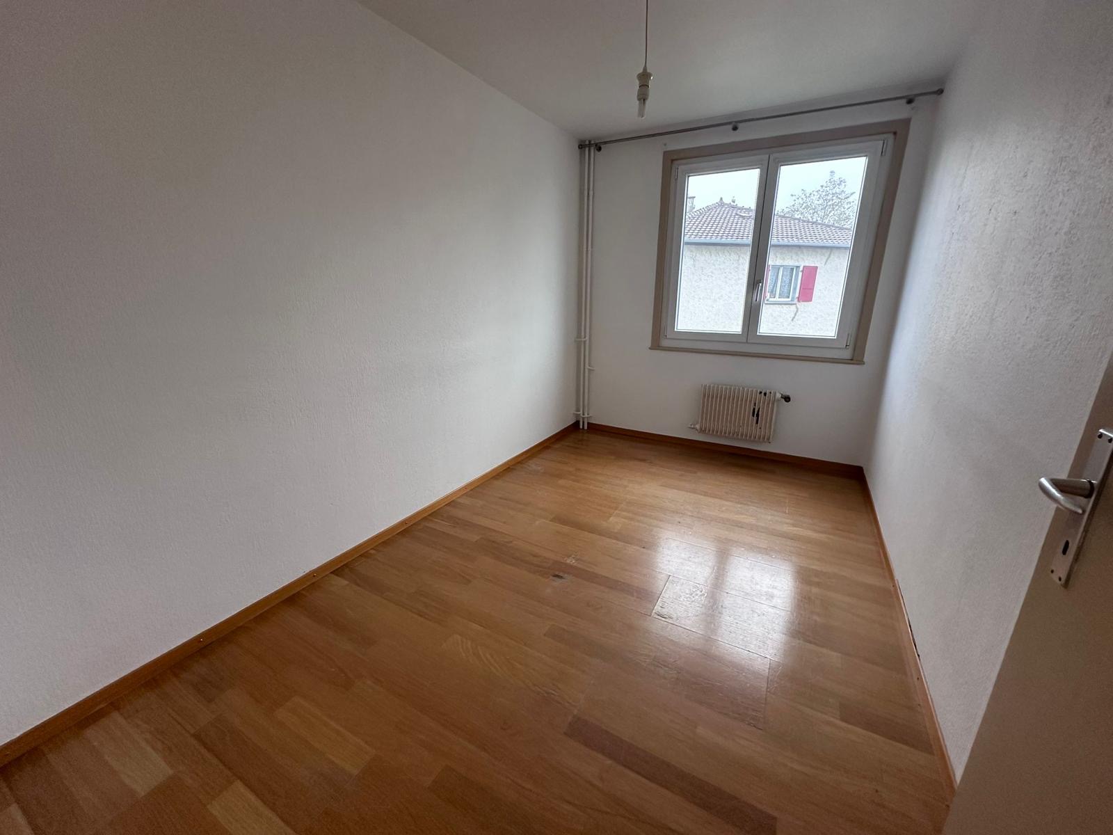 Chambre avant travaux avec fenêtre, radiateur et murs défraîchis