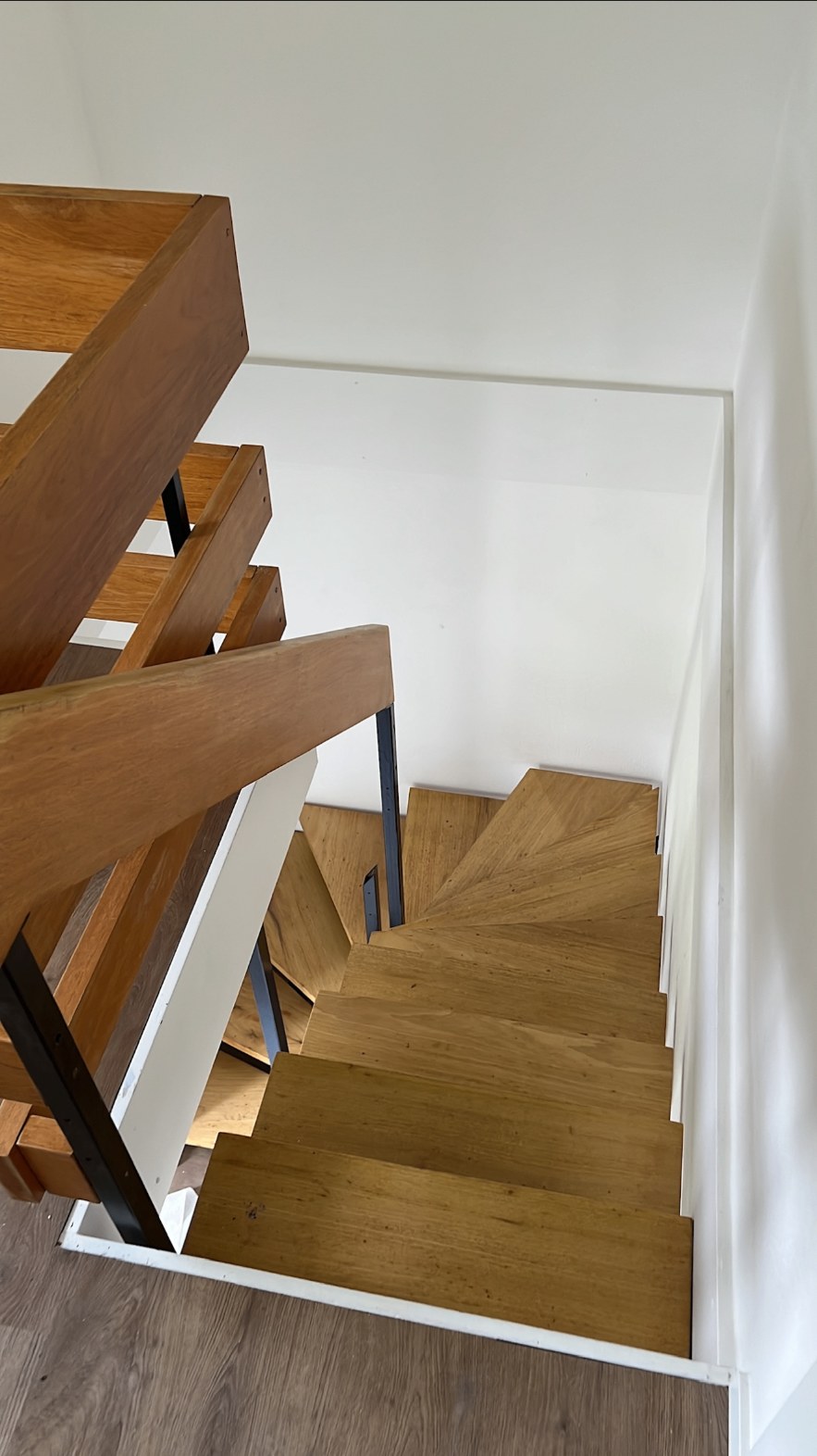 Cage d'escalier en bois avec murs et plafonds repeints en blanc