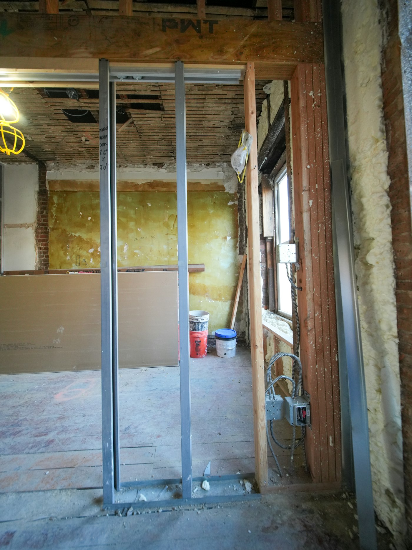 Cloison sur ossature métallique en cours de montage, plaques de plâtre prêtes à être posées