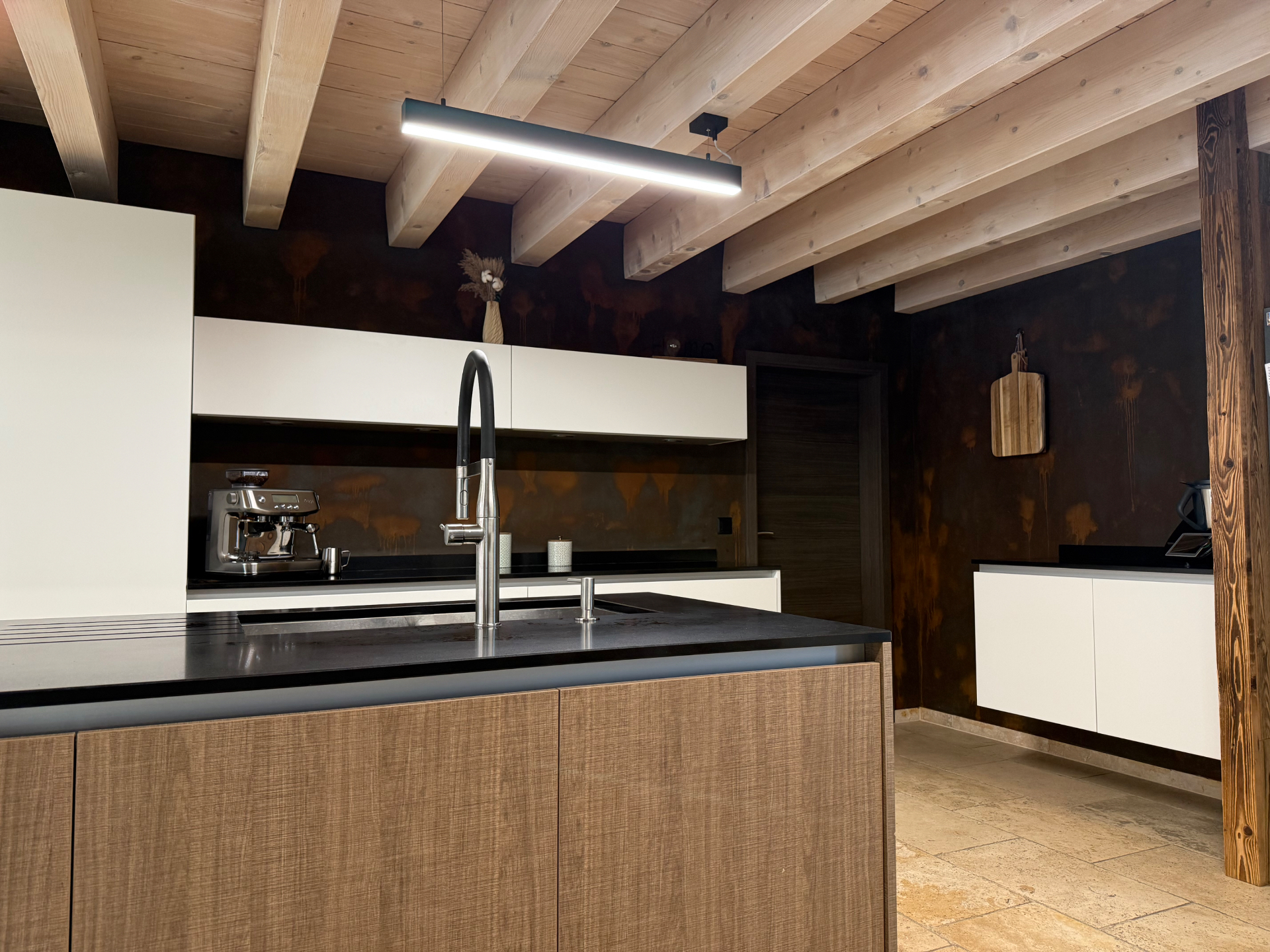 Cuisine contemporaine avec murs en peinture décorative effet rouille et plafond en poutres apparentes