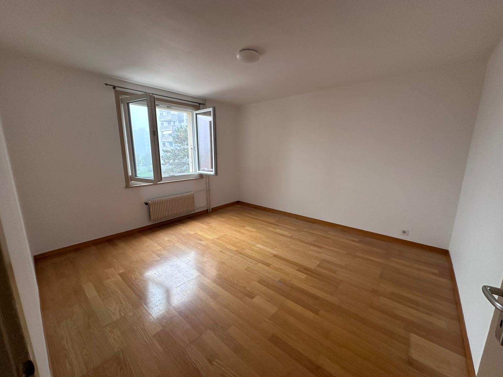 Chambre avant travaux, parquet en bois et murs marqués