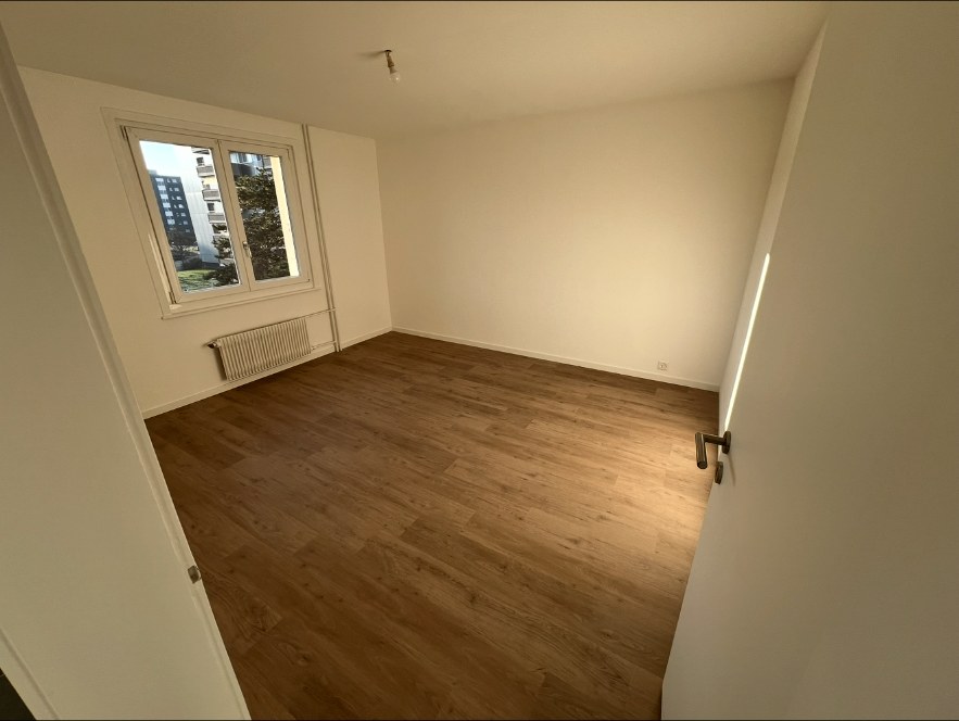 Chambre après travaux avec murs clairs et sol bois protégé