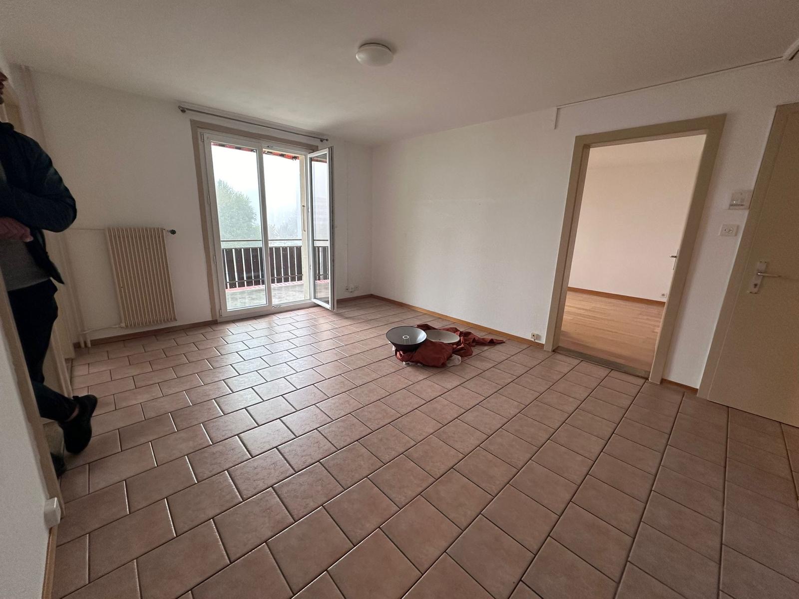 Séjour avant travaux avec carrelage rose et murs à rafraîchir