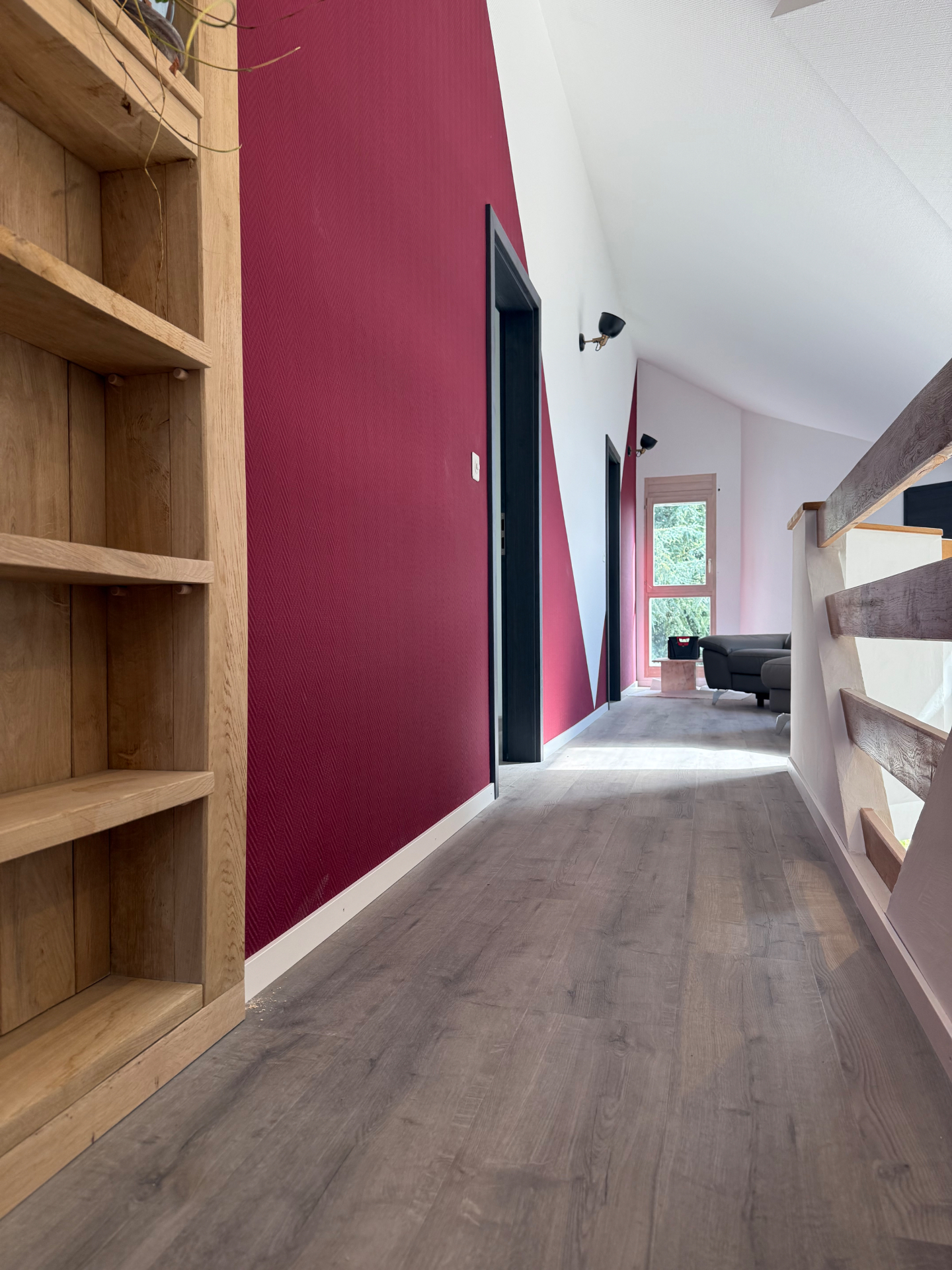 Couloir intérieur avec grand mur bordeaux et plafond blanc