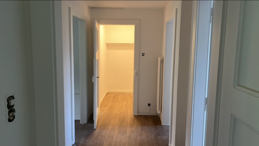 Couloir repeint en blanc avec plusieurs portes et encadrements laqués