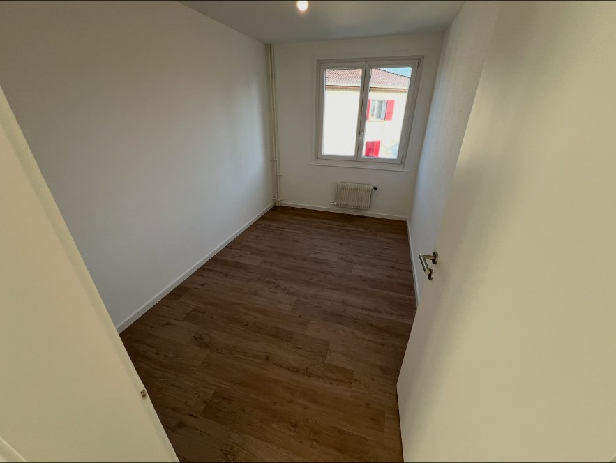 Chambre après travaux avec murs blancs et encadrement de fenêtre repeint